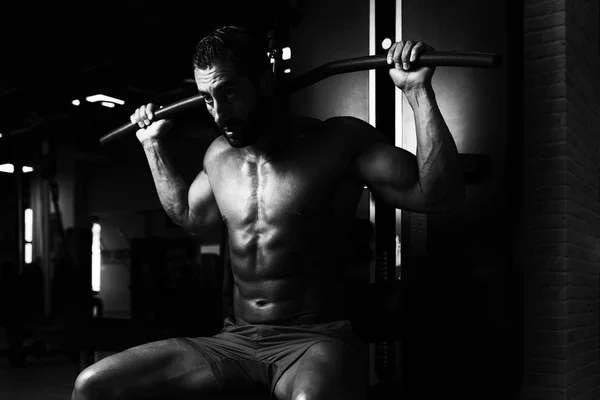 Мускулистый человек делает тяжелые упражнения веса для спины — стоковое фото