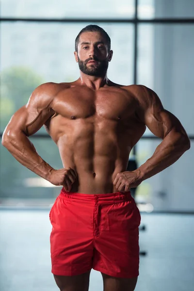 Hombre joven saludable Flexing Músculos — Foto de Stock