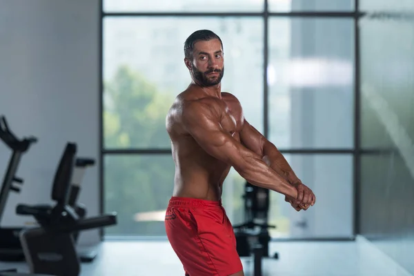 Jonge Bodybuilder buigen spieren zijkant borst Pose — Stockfoto