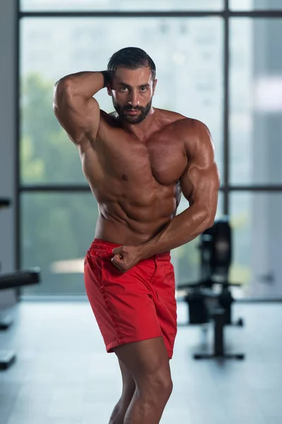 Bodybuilder presterende kant borst vormen — Stockfoto