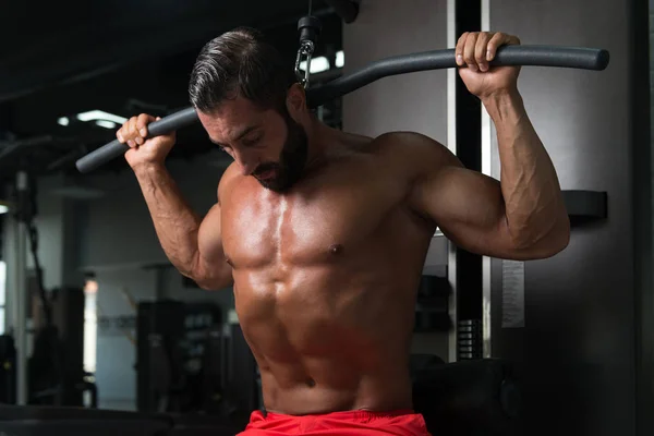 Muscular Man Exercising Back On Cable Machine — Stok Foto