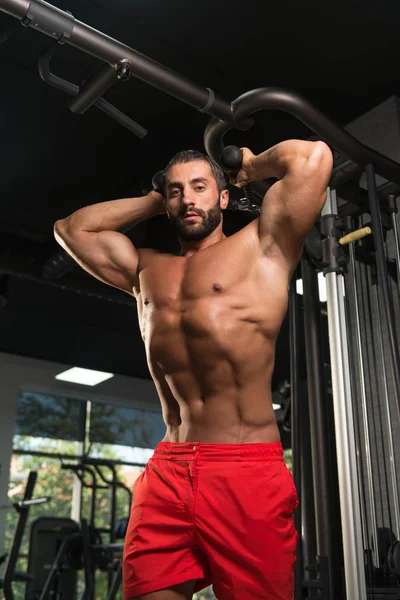 Hombre hispano haciendo tríceps en el gimnasio — Foto de Stock