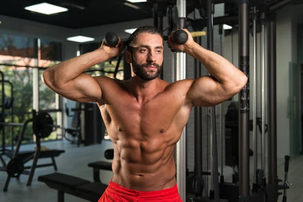 Hombre hispano haciendo tríceps en el gimnasio — Foto de Stock