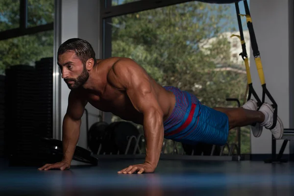 Hombre Ejercicio push ups con correas de fitness Trx —  Fotos de Stock