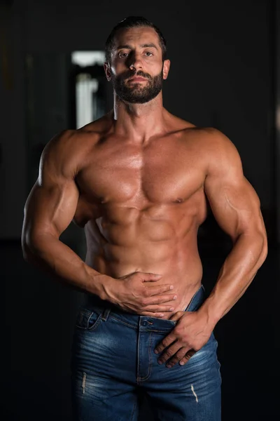 Muscle man poseren in sportschool — Stockfoto