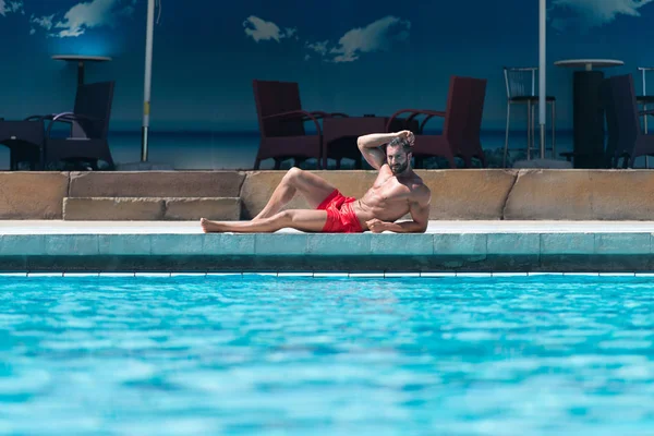 수영장에서 휴식 하는 섹시 한 남자 — 스톡 사진