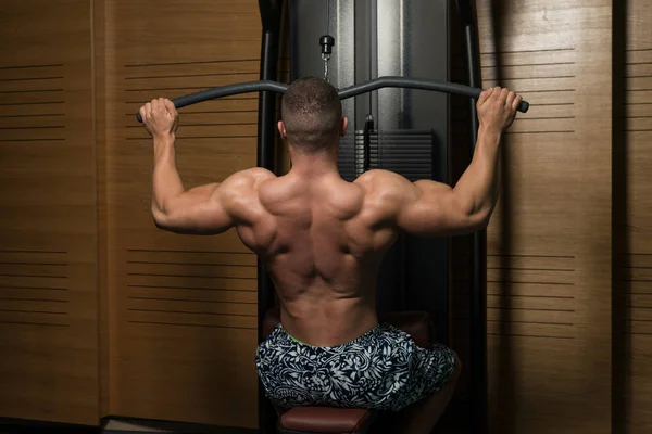 Fitness Muscle Man Exercício de volta na máquina — Fotografia de Stock