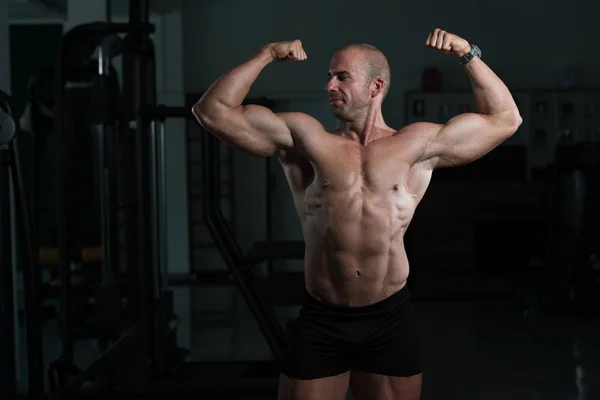 Bodybuilder posiert im Fitnessstudio mit doppeltem Bizeps — Stockfoto