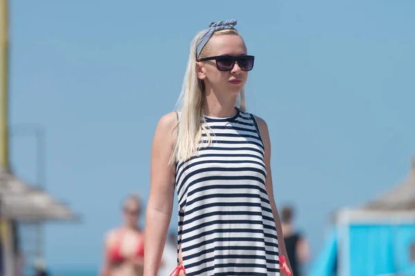 Giovane donna che cammina sulla spiaggia — Foto Stock