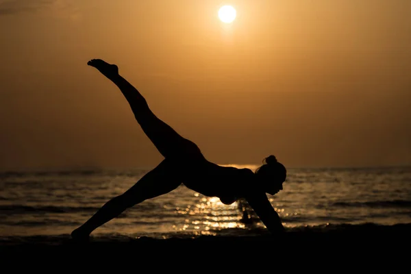Žena, která dělá meditace poblíž Ocean Beach Yoga silueta — Stock fotografie