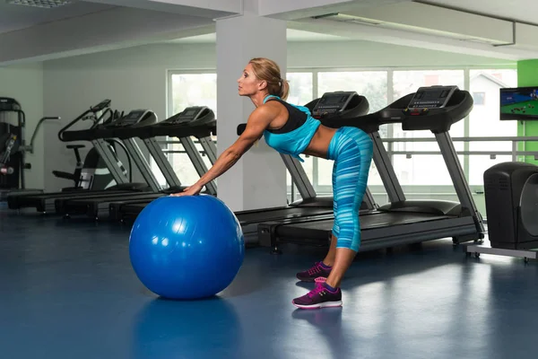 Mogen kvinna gör övning på bollen i Gym — Stockfoto