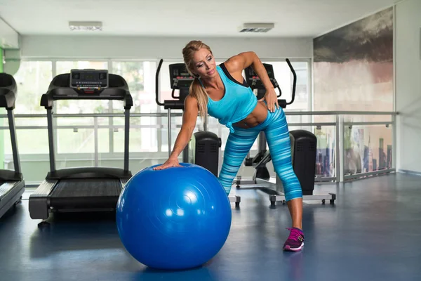 Mulher fazendo exercício de peso pesado na bola — Fotografia de Stock