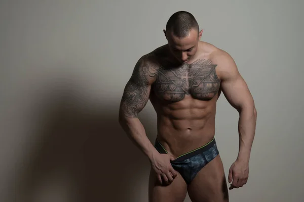 Sexy tatuaje hombre aislado sobre fondo gris — Foto de Stock