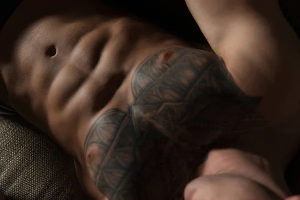 Крупним планом татуювання молодий чоловік лежить у ліжку — стокове фото