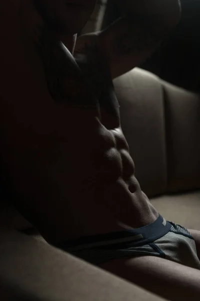 ソファに横たわる強い上半身裸の若い男 — ストック写真