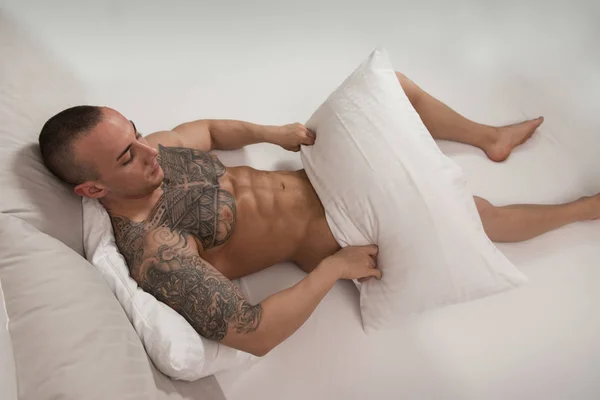 Aantrekkelijke man in zijn bed liggen — Stockfoto