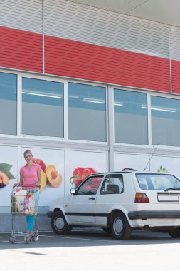 Süpermarket yakınındaki mutlu güzel kadın portresi