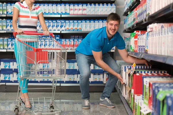 Couple souriant achetant des produits laitiers dans un supermarché — Photo