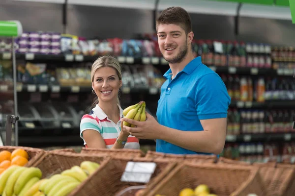 Pareja comprando frutas y verduras en el supermercado —  Fotos de Stock