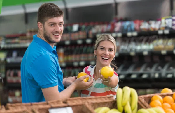 Pareja sonriente comprando productos lácteos en el supermercado —  Fotos de Stock
