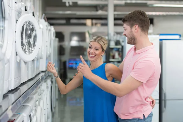 Coppia sorridente acquistare lavatrice nel supermercato — Foto Stock