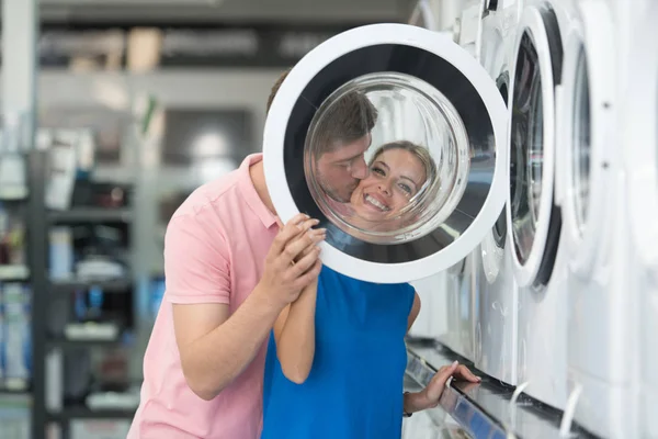 Sorrindo casal compra máquina de lavar roupa no supermercado — Fotografia de Stock