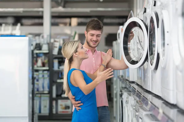 Bela jovem casal compras máquina de lavar no supermercado — Fotografia de Stock