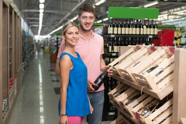 Couple souriant achetant Vino au supermarché — Photo