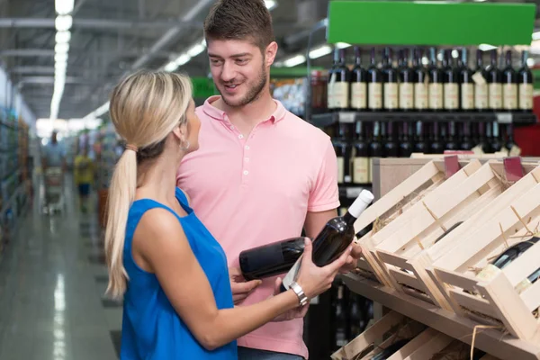 Mooie jonge koppel winkelen Vino In supermarkt — Stockfoto