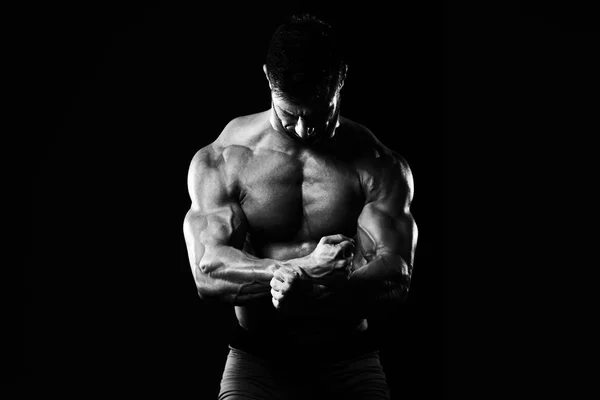 Uomo muscolare che flette i muscoli in palestra — Foto Stock