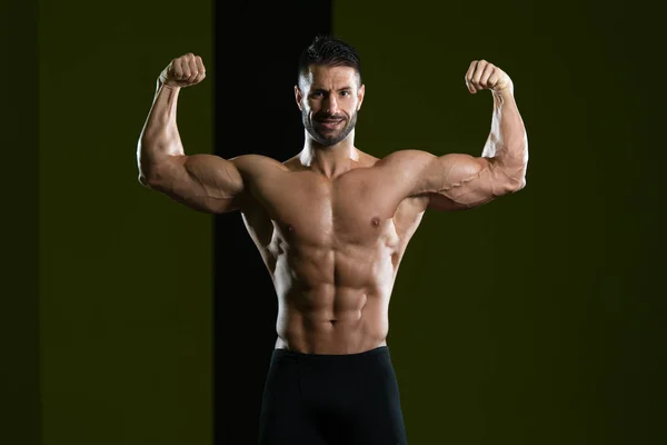 Muskularny mężczyzna wyginanie mięśni w siłowni — Zdjęcie stockowe
