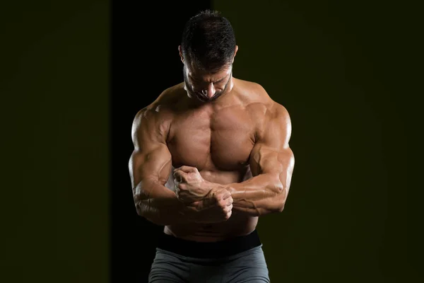 Homem muscular flexionando músculos no ginásio — Fotografia de Stock