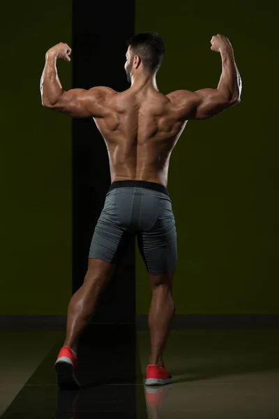 Jonge bodybuilder buigen spieren — Stockfoto