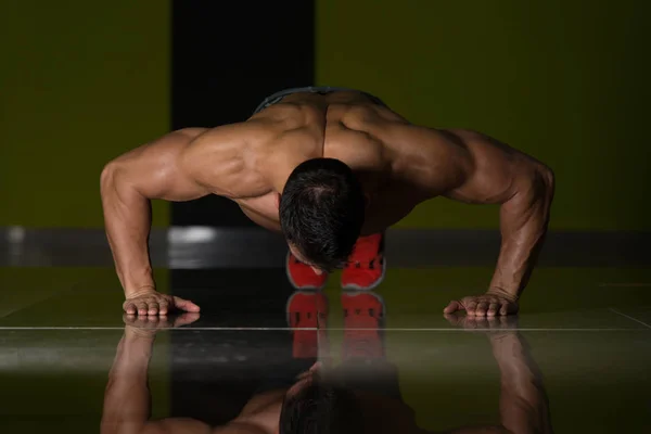 Musclé homme effectuant push ups sur le sol — Photo