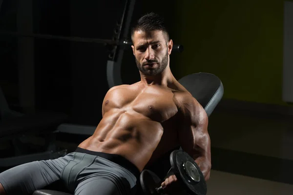 아령으로 팔 뚝 운동을 하는 근육 질의 남자 — 스톡 사진