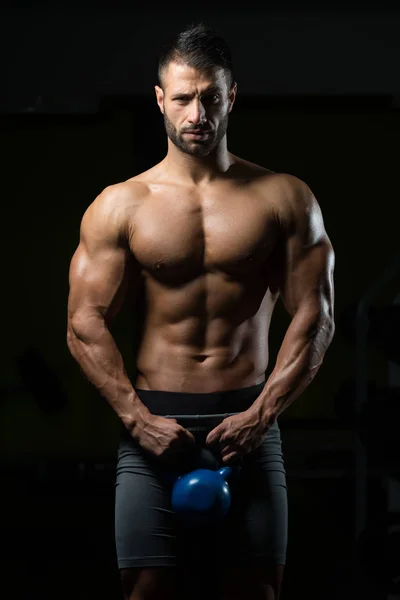 Homem de fitness usando Kettlebells dentro do ginásio — Fotografia de Stock