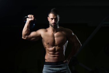 Genç adam su ısıtıcısı çan ile egzersiz