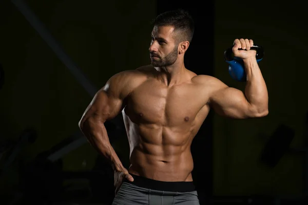 Muskulös Man tränar med vattenkokare-bell — Stockfoto