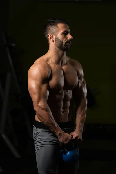 Ejercicio de hombro con hervidor de agua en un gimnasio — Foto de Stock