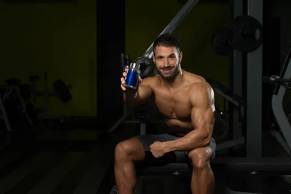 Bodybuilder Posing With Supplements For Copy Space — Stock Photo, Image