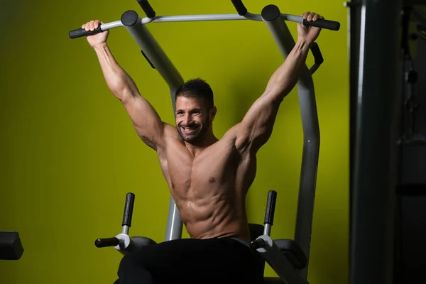 Joven hombre realizando colgante pierna plantea ejercicio — Foto de Stock