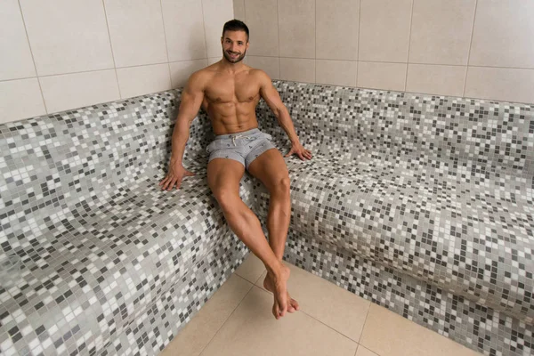 Retrato de un hombre musculoso relajándose en la sauna — Foto de Stock