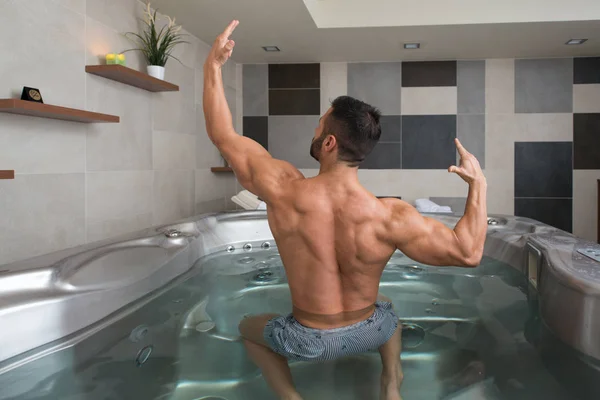 Flexing Muscles in Hot Tube Jacuzzi