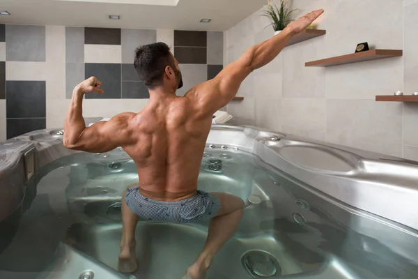 Guy Flexing Músculos em Azure Jacuzzi — Fotografia de Stock