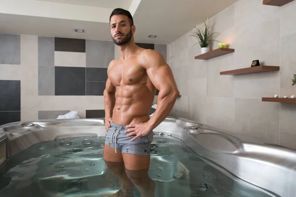 Man Flexing Muscles in Jacuzzi Spa — Stock Photo, Image