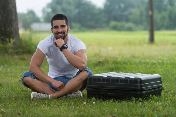 Man zit op gras met koffer van Drone — Stockfoto