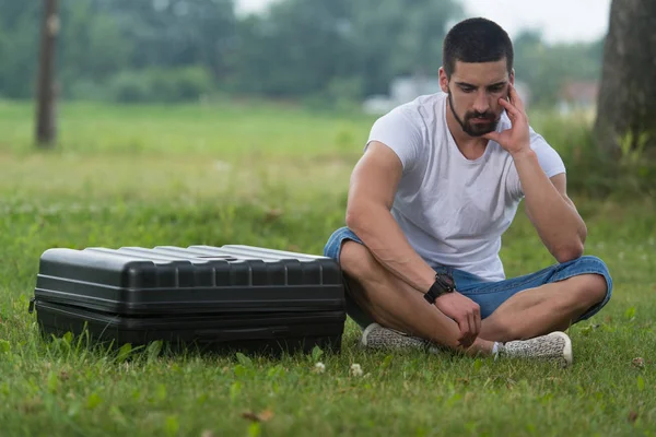 Frustrado homem sentado na grama com caso Drone — Fotografia de Stock