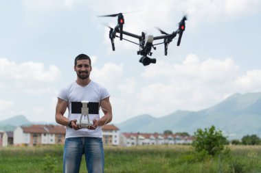 Adam açık havada uçan bir dron uzaktan kumanda ile