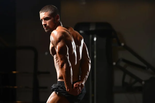 Sérieux jeune bodybuilder debout dans la salle de gym — Photo