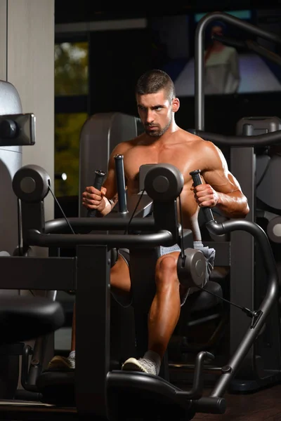 Νέοι Bodybuilder άσκηση πίσω στο μηχάνημα — Φωτογραφία Αρχείου